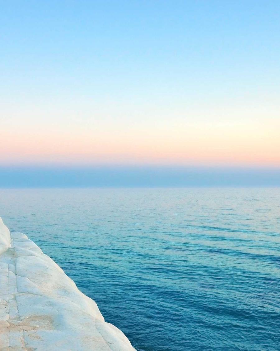 Mer calme au lever du jour vue depuis une falaise de roche blanche